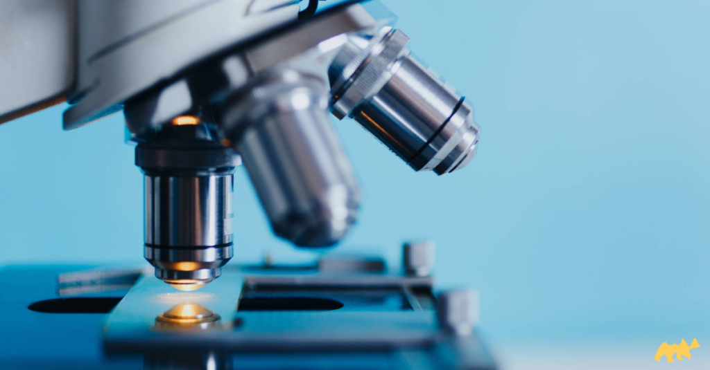A close up of a microscope with a blue background.