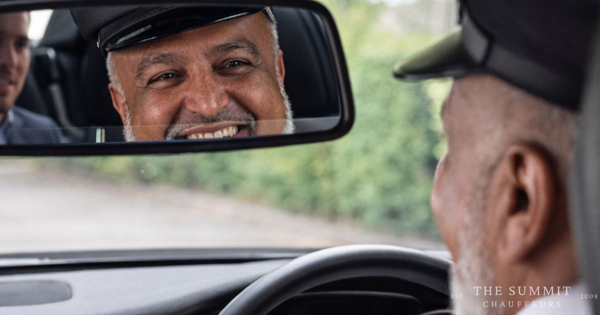 Founder of The Summit Chauffeurs, Rehan Jamil, looking in the rear view mirror at a client in the backseat